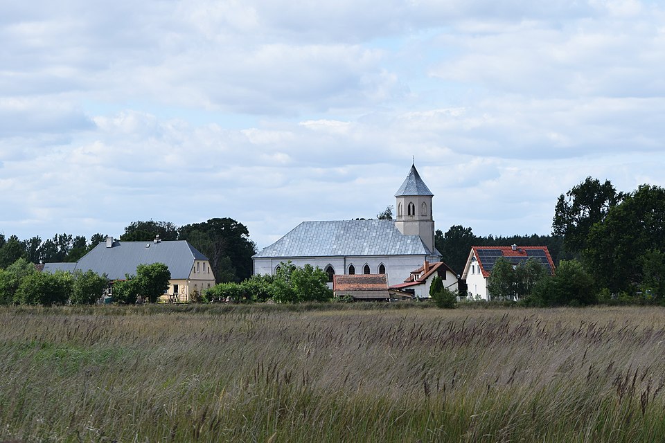 Widok na wieś Sądowel od południa, z Kościołem Matki Boskiej Królowej Świata w centrum  (fot. Krzysztof Ziarnek/Wikipedia)