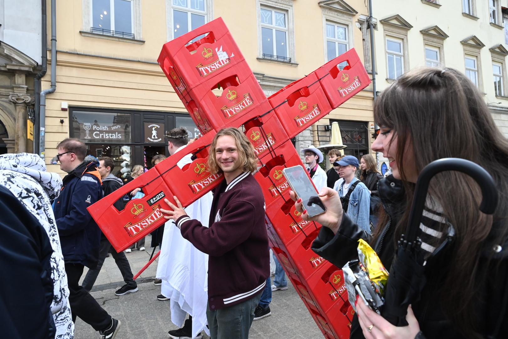 Pochód juwenaliowy w Krakowie 2026. Na zdjęciu jeden ze studentów, który przebrał się za Jezusa dźwigającego krzyż zrobiony ze skrzynek na butelki po piwie. Fot. Marek Lasyk